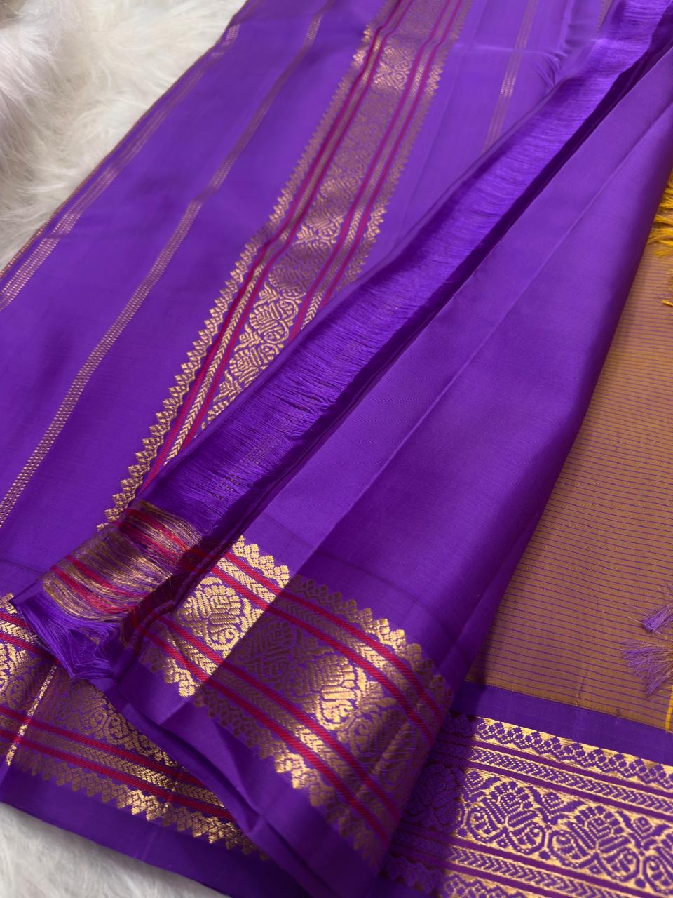 Purple gold zari border detail on canary yellow Kanjivaram saree
