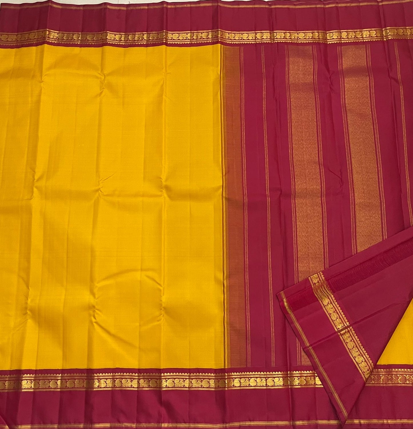 Arakku red pallu of canary yellow Kanjeevaram pure silk saree with Kaal Irangiya and paisley antique gold zari cascade