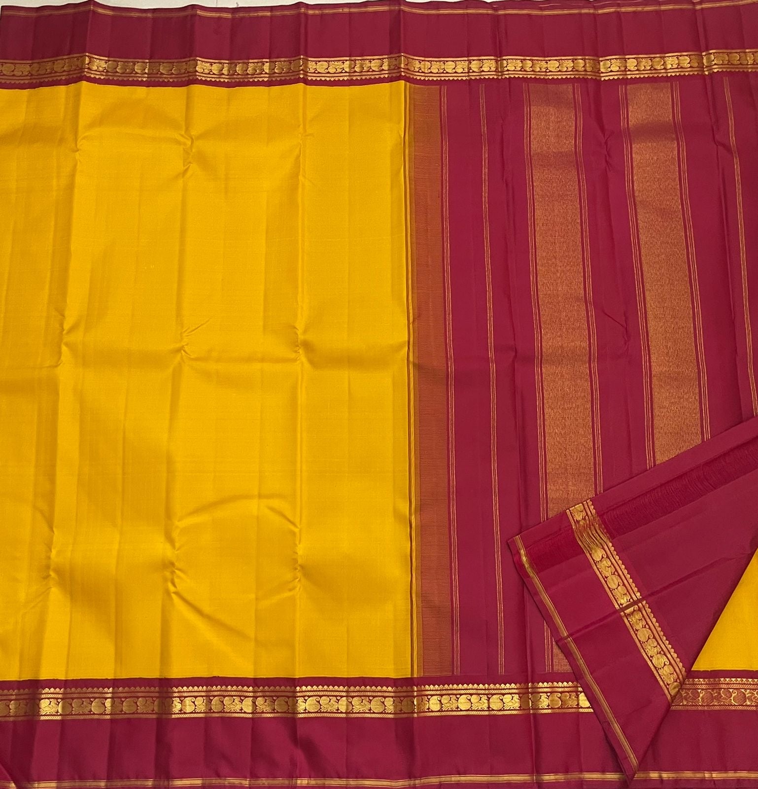 Arakku red pallu of canary yellow Kanjeevaram pure silk saree with Kaal Irangiya and paisley antique gold zari cascade