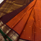 Saree spread open with rust orange body, tiny zari buttas, and a deep maroon pallu featuring dense zari woven patterning.