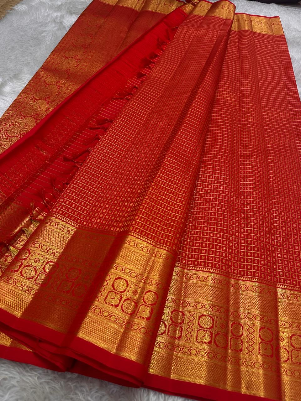 Chakram medallions and traditional bird motifs on the Sevappu Red gold-zari border.