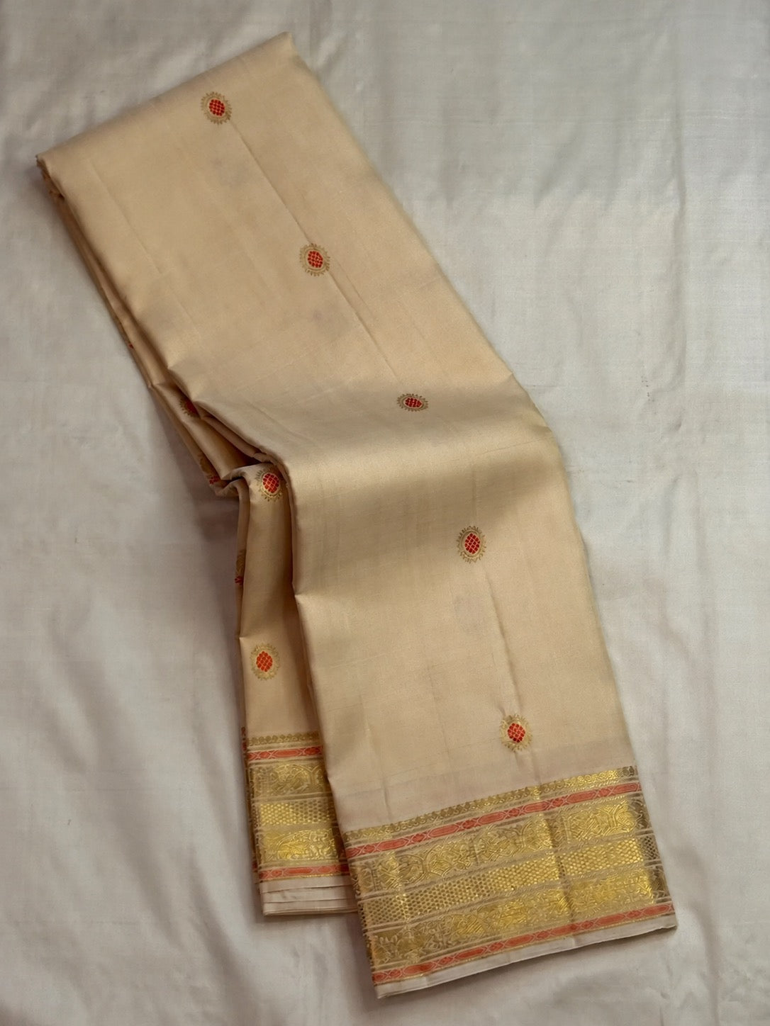 Full view of the Chandanam handwoven pure silk Kanchipuram butta saree with meenakari orange kamalam buttas and Sorgavaasal border.