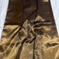 Folded bronze and antique-gold Chanderi handloom silk showing luminous texture and warm gold-toned border detail.