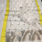 Ivory Pattu silk Chanderi saree laid open showing grey floral-bud buttas, lemon-yellow border and silver-toned pallu