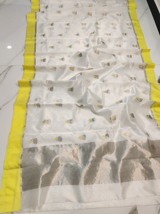 Ivory Pattu silk Chanderi saree laid open showing grey floral-bud buttas, lemon-yellow border and silver-toned pallu