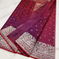 Front pleats of a berry red Chanderi Katan Silk saree showing tiny silver blossoms