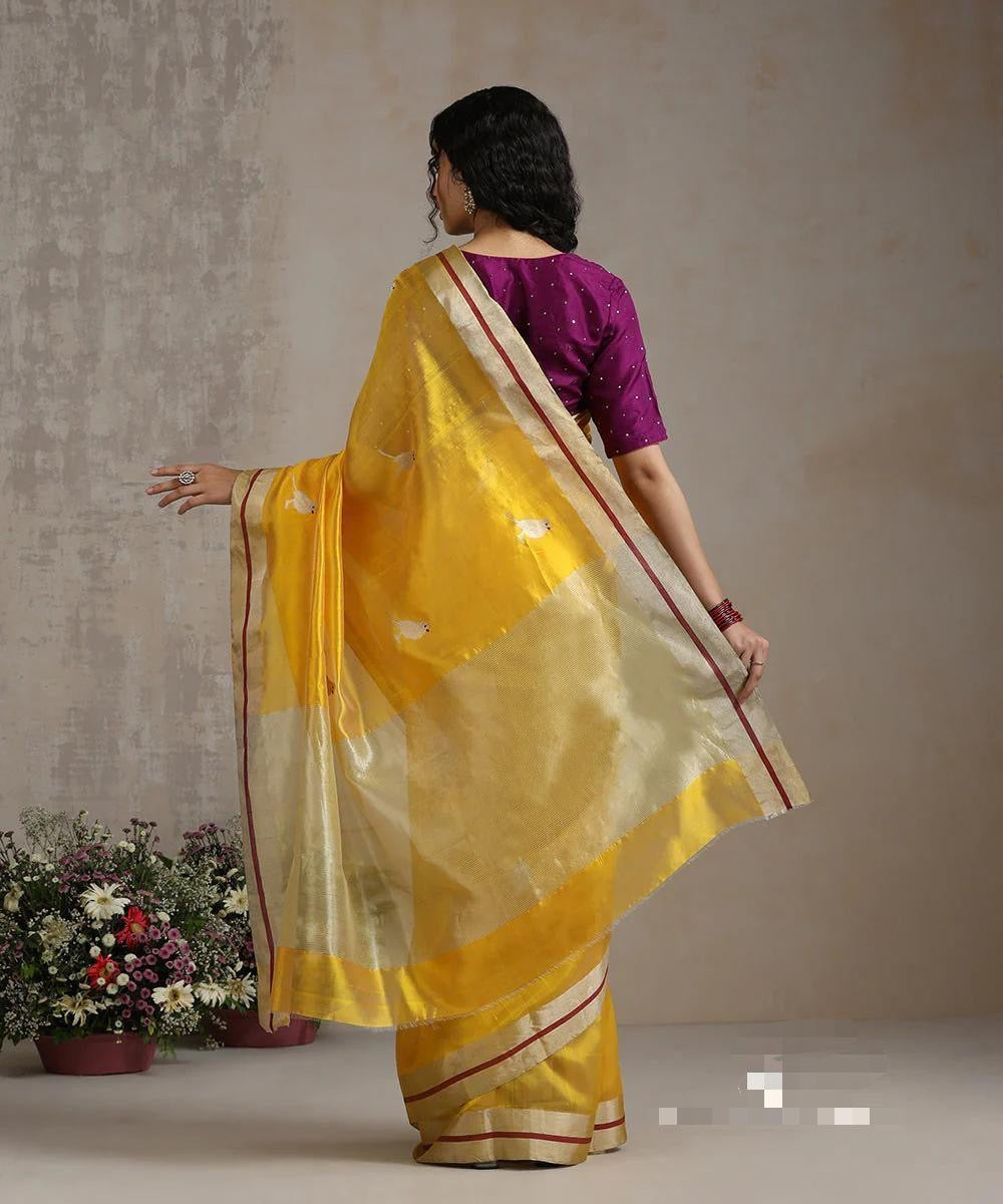 Marigold yellow Chanderi silk saree styled with gold jewellery, rust-red edge stripes visible