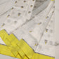 Ivory Chanderi Pattu silk saree folded to show the lemon-yellow border and grey floral buttas on the sheer body