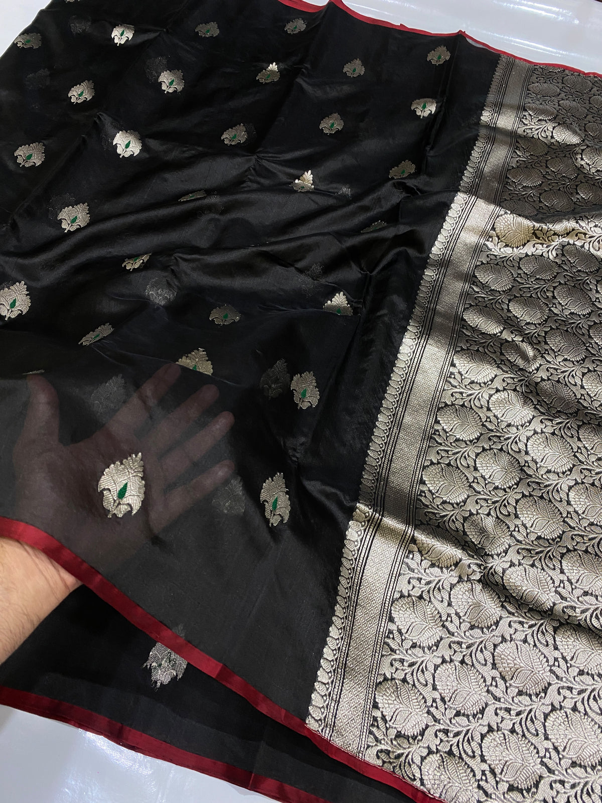 Border close-up of a black Chanderi silk saree with fine burgundy-red edging