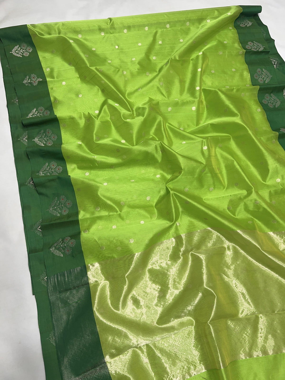 Detail of silver floral buttas on the Parrot Green Pattu Silk Chanderi saree