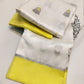 Folded ivory Chanderi Pattu silk saree with lemon-yellow border and grey floral-bud buttas