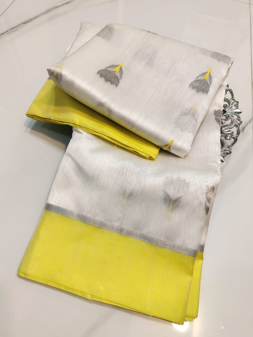 Folded ivory Chanderi Pattu silk saree with lemon-yellow border and grey floral-bud buttas