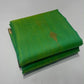 Folded sea glass green Chanderi Katan silk saree highlighting a gold-toned buti and the fresh green shot silk texture