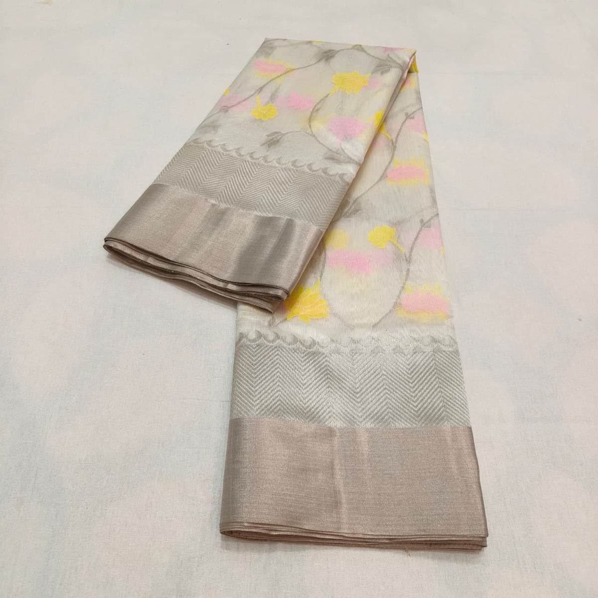 Close view of warm ivory Chanderi silk with pastel floral motifs