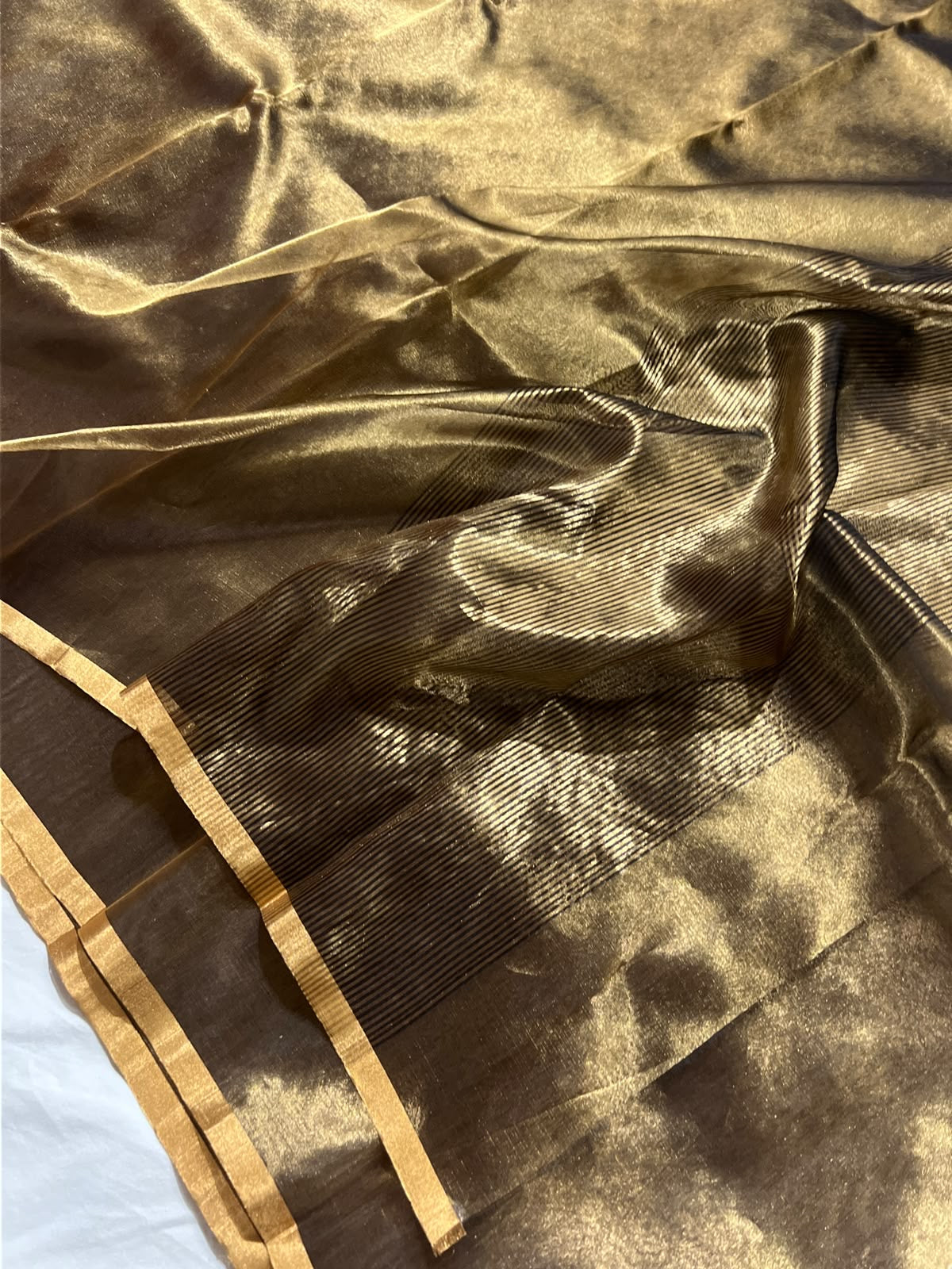 Burnished bronze Chanderi Katan Silk saree with antique-gold sheen, narrow golden borders and fine dark striped pallu.