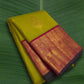 Chartreuse green handwoven Kanchi Pattu saree folded showing magenta Korvai border and flower butta body — Idam Living