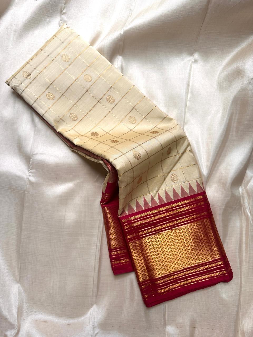 Ivory kattam Pure Kanchipuram silk saree drape showing zari buttas and a tomato red border with gold zari woven detailing.