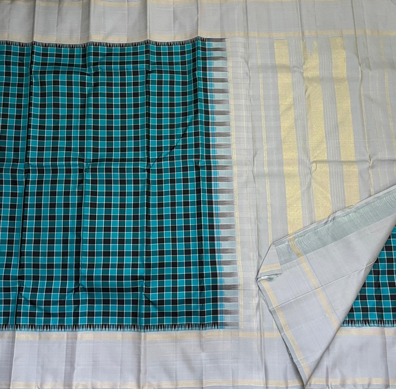 Close-up corner of teal and black checked Pure Kanchipuram silk saree beside silver pallu with zari woven bands