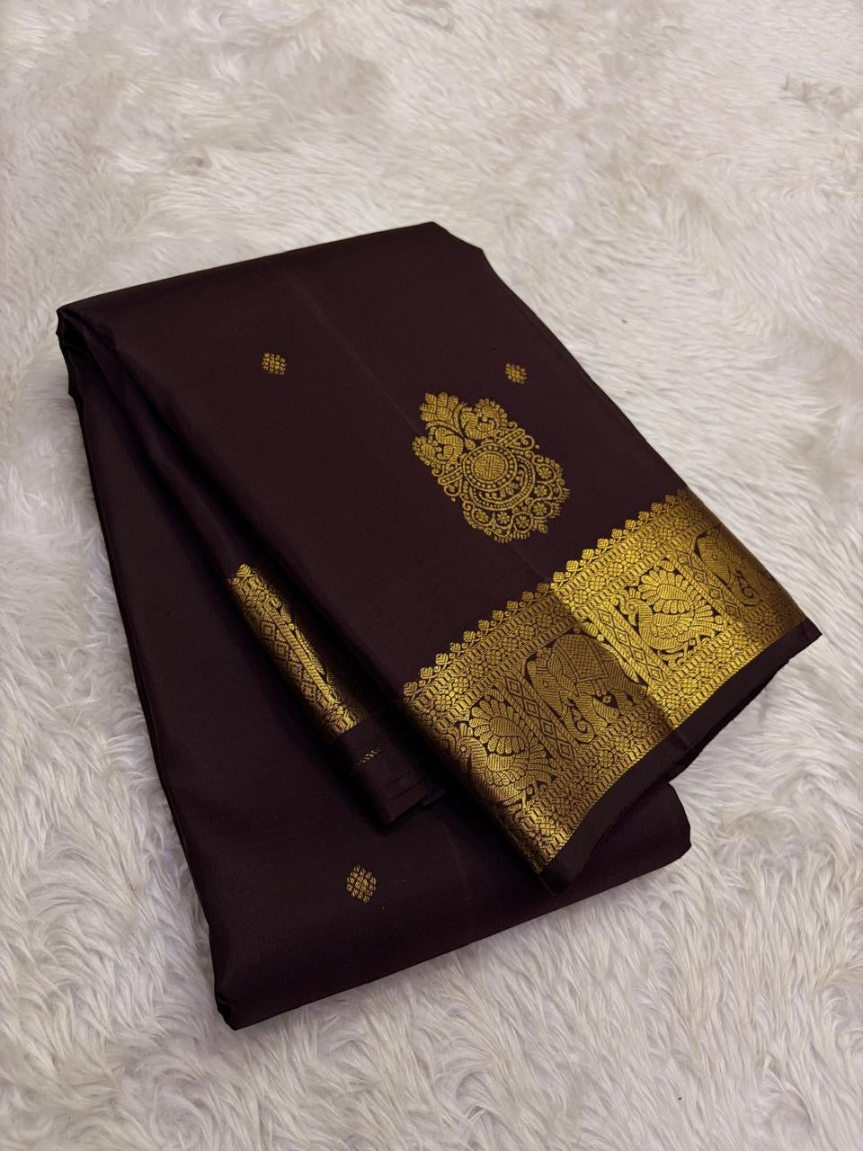 Deep chocolate brown Kanjipuram silk saree body close-up showing Maanga paisley gold zari butta motifs