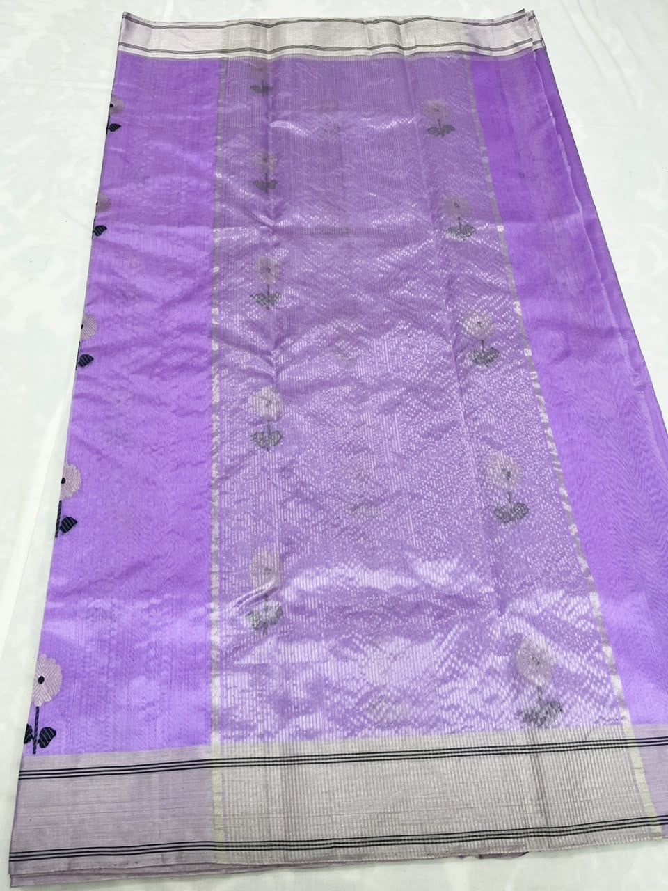 Lilac Chanderi saree opened to show the silver-toned striped borders and luminous floral pallu