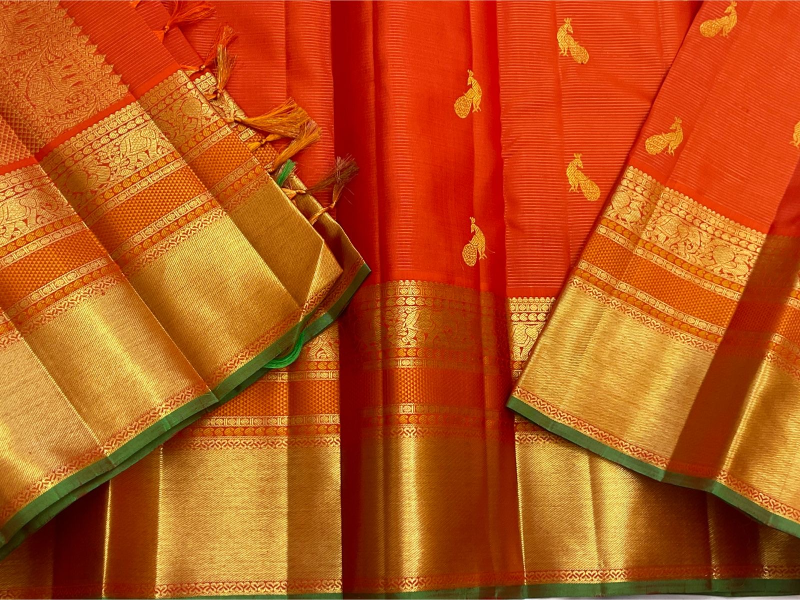 closeup of gold zari pallu detailing on vermillion orange kanchipuram silk saree shipped from New Jersey USA