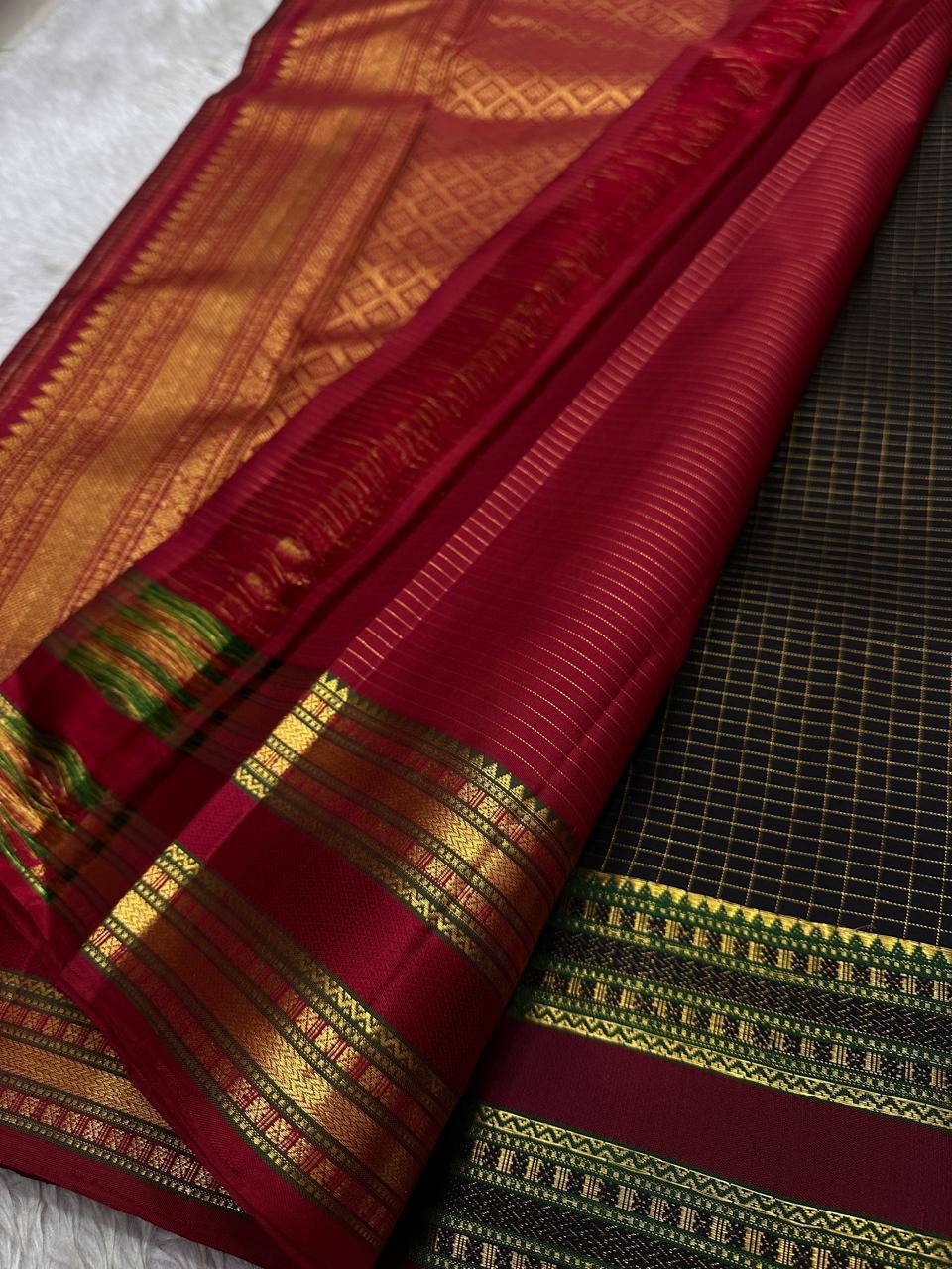 Angled black Kanchipuram silk saree showing antique gold zari checks with woven butta motifs and maroon border