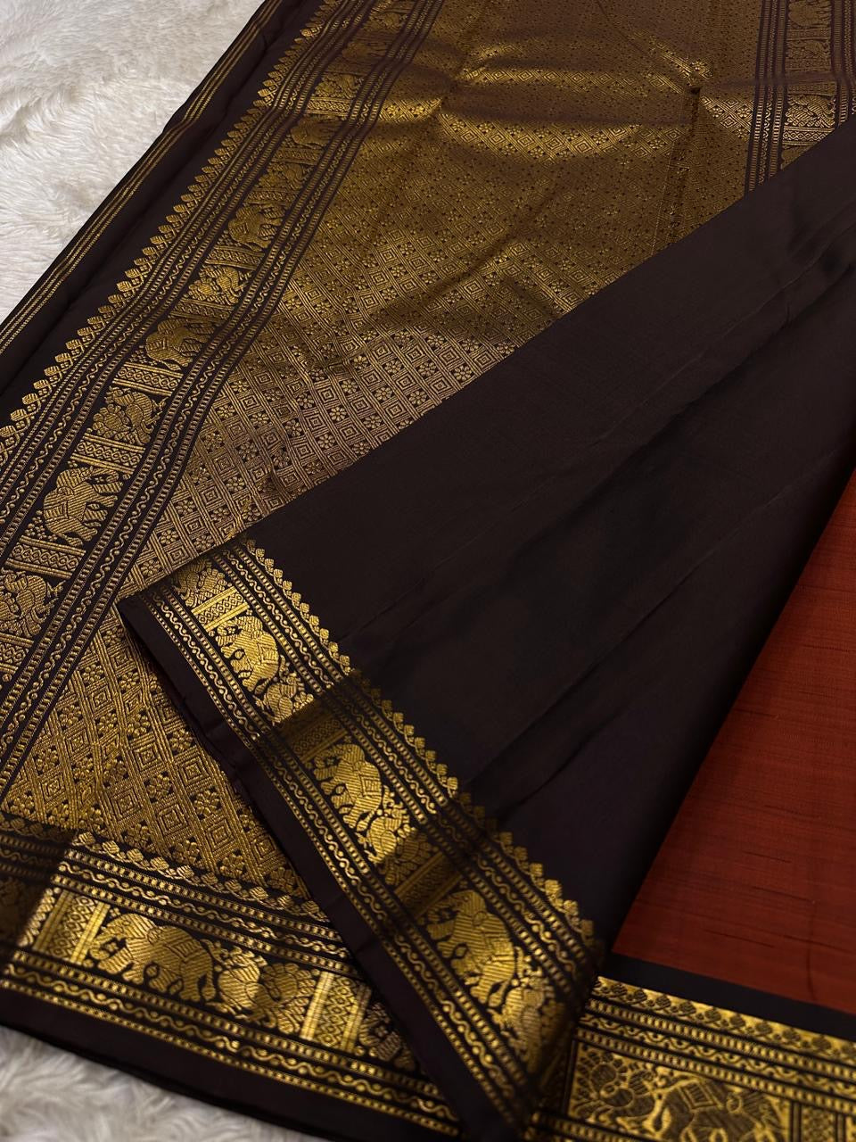 Close view of black zari woven pallu with dense gold geometric weave and elephant border detailing on Pure Kanchipuram silk saree.