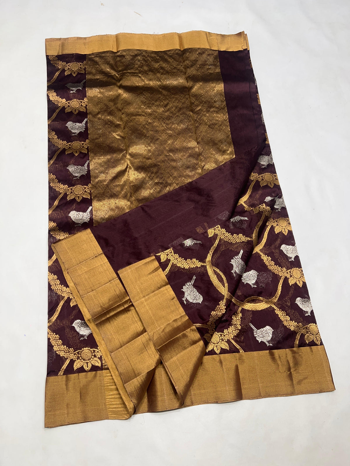 Draped Cocoa Brown handloom Chanderi showing gold curving floral vines, silver bird motifs and luminous antique-gold pallu.