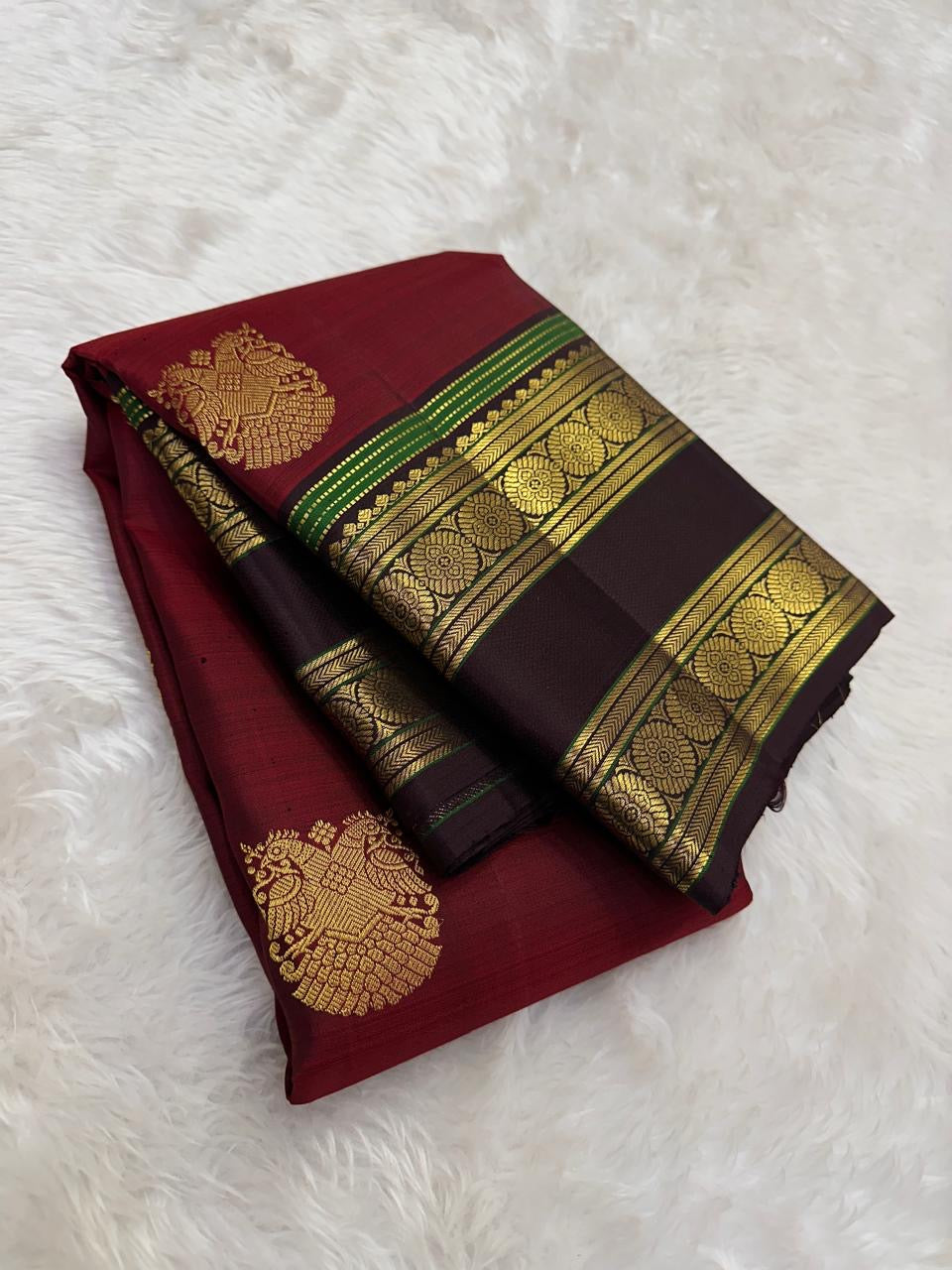 Coffee-brown rettapet border with green highlights on the arakku red saree.