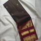 Deep Coffee Brown Zari Kattam body with petite gold buttas and elaborate peacock zari border in Arakku Red.