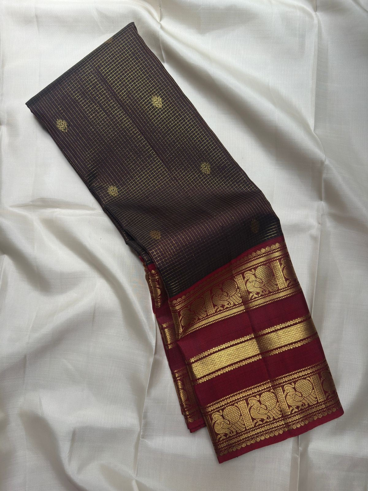 Deep Coffee Brown Zari Kattam body with petite gold buttas and elaborate peacock zari border in Arakku Red.