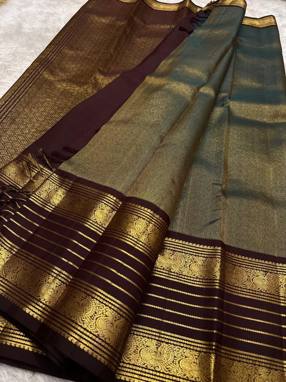 Muted celadon-toned contrast section on the coffee brown saree.