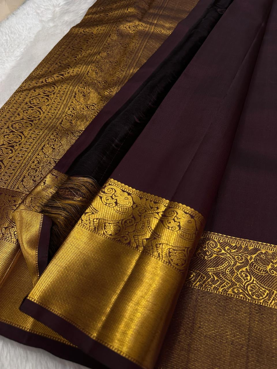 Coffee brown Kanchipattu handwoven pure silk saree, folded view with floral jaal border.