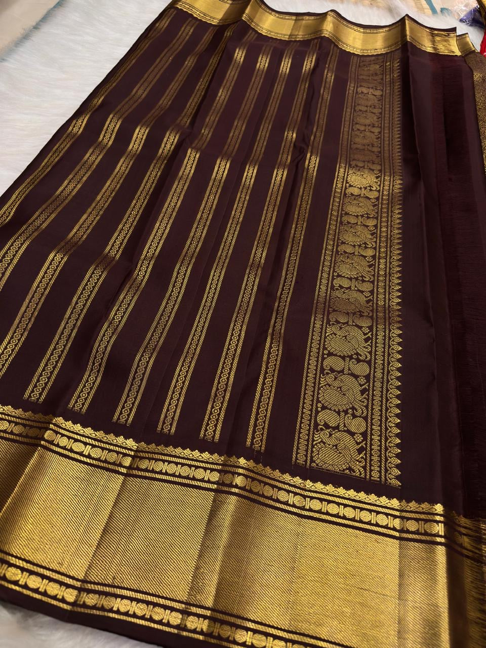 Deep cinnamon brown Kanchipuram saree pallu with dense gold zari jaal and broad classic zari border