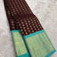 Fresh turquoise gold-zari border paired with deep coffee-brown silk in a traditional Kancheepuram saree.