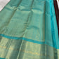 Opened coffee-brown silk body showing alternating gold kamalam and peacock buttas beside the turquoise border.