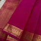 Close-up of magenta zari woven pallu with dense gold pattern and matching zari woven border on silk saree.