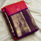 Handwoven coral silk body shifting toward amethyst with a deep violet contrast Kanchipuram border.