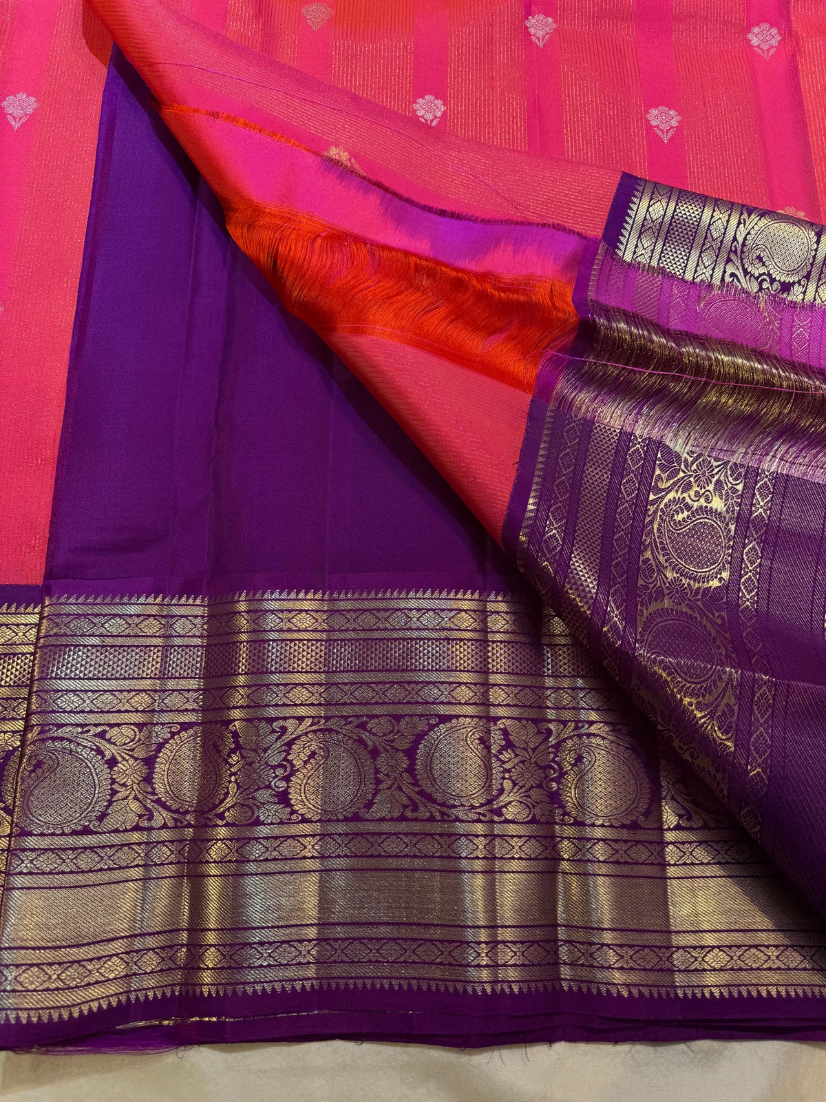 Coral-amethyst Korvai Kanchipuram saree showing deep purple stacked zari border.