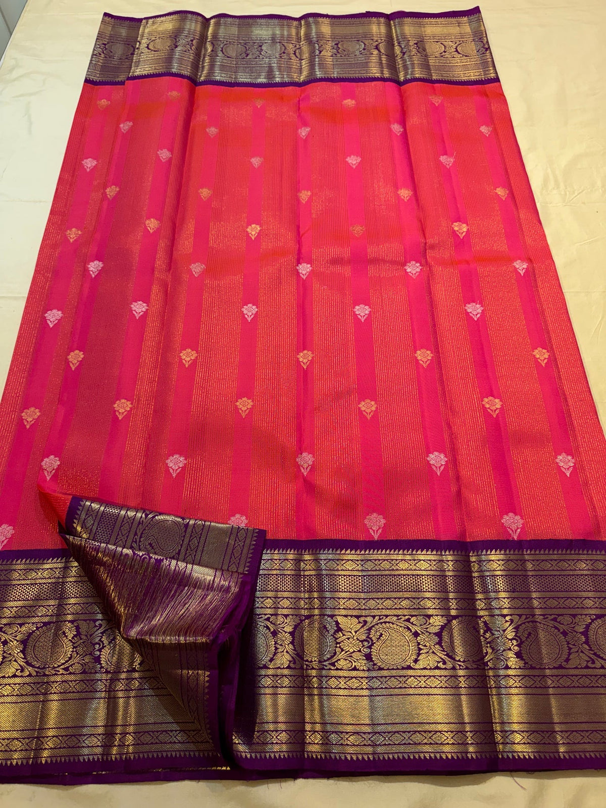 Full handwoven Kanjivaram saree with luminous coral body and amethyst-violet contrast sections.