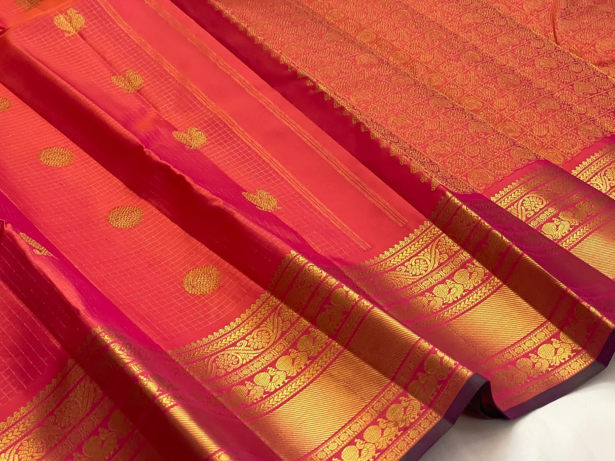Coral and sunset orange double-shot silk with Zari Kattam checks on a handwoven Kanchipuram saree