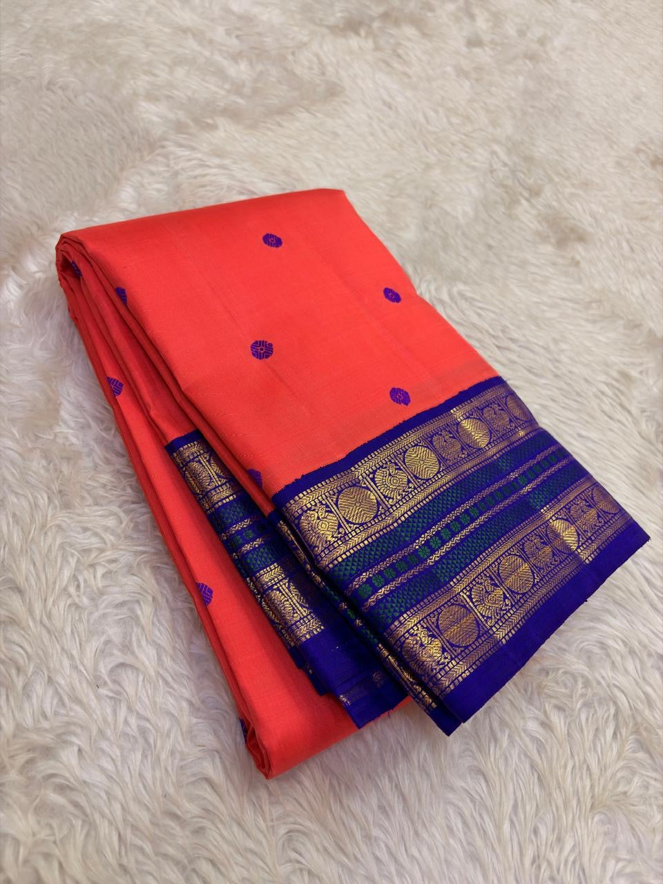 Coral orange Kanjivaram silk saree with royal violet korvai border – drape view