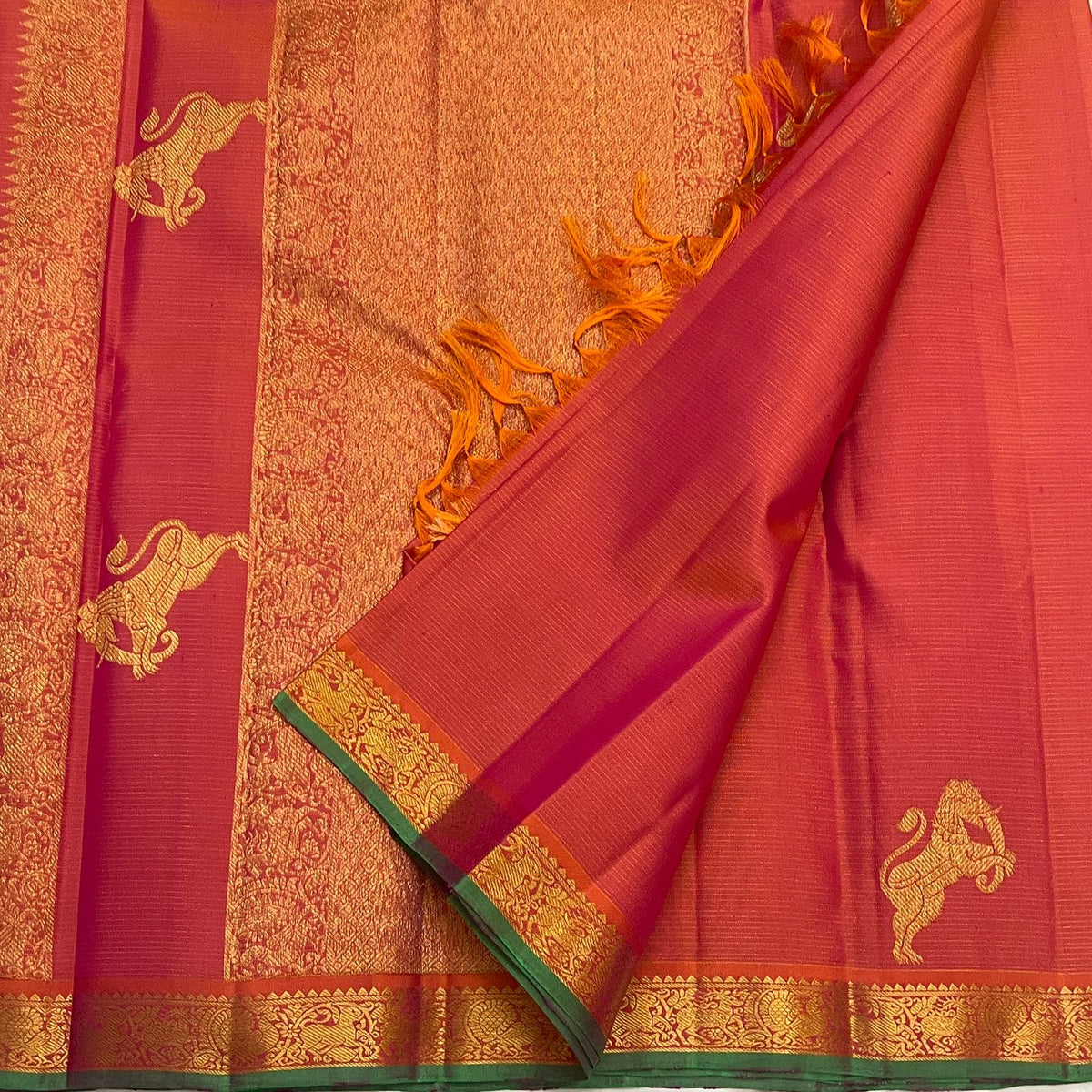 Handwoven Kanchipuram saree with Coral Rose body, Yazhi motifs and delicate parallel zari lines.