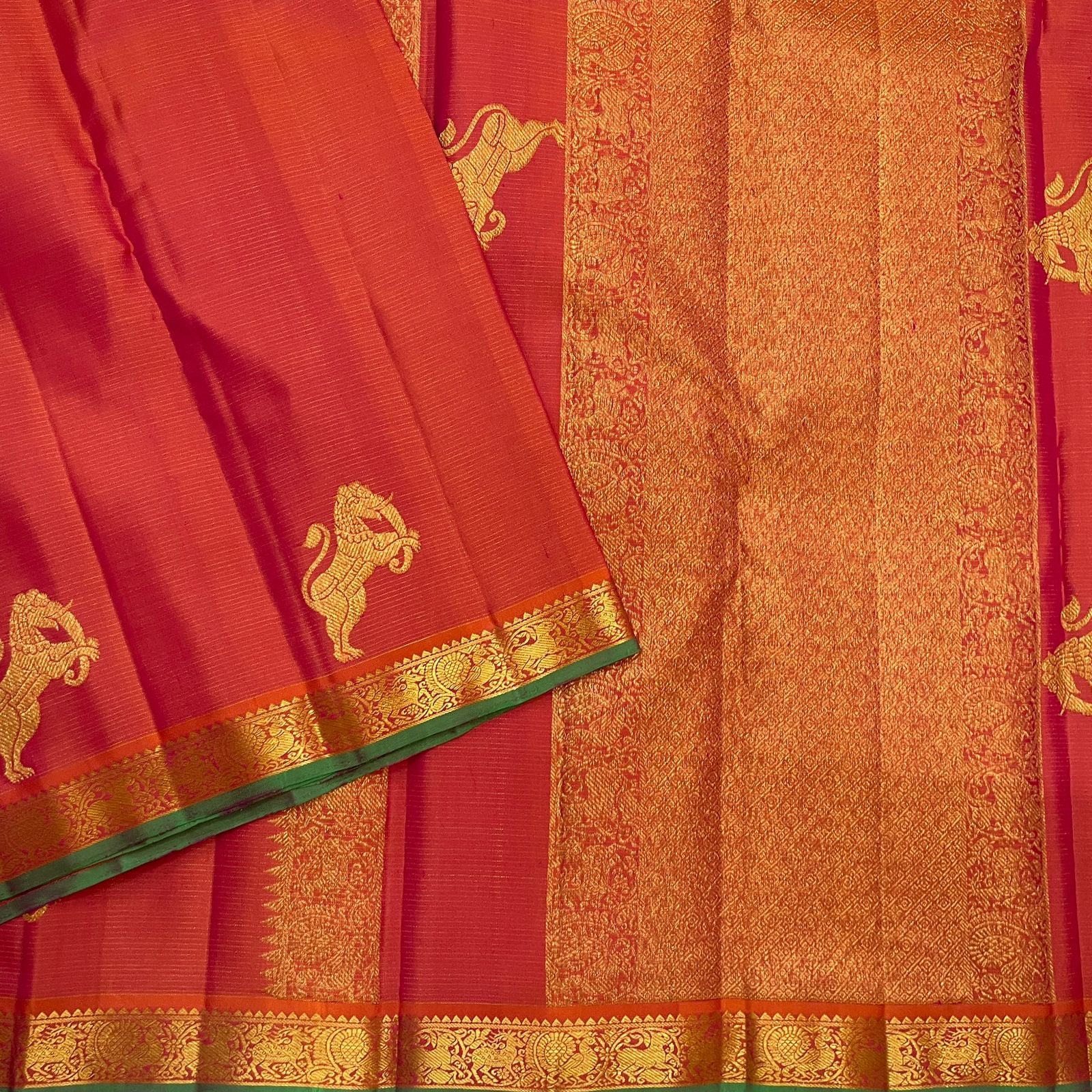 Close view of large handwoven Yazhi motif in warm gold zari on radiant Coral Rose silk.