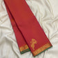 Coral pink orange Kanchi Pattu saree with fine directional Vairaoosi zari lines and green selvedge.