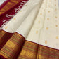 Deep Arakku-red Korvai border with layered classic-gold zari registers and ornamental woven detailing.