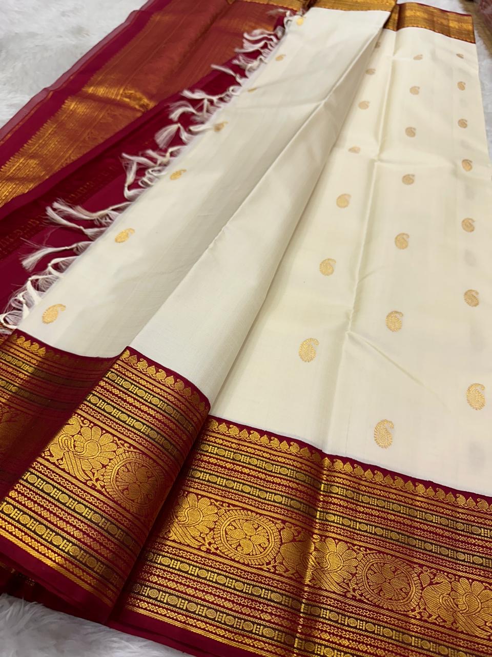Deep Arakku-red Korvai border with layered classic-gold zari registers and ornamental woven detailing.