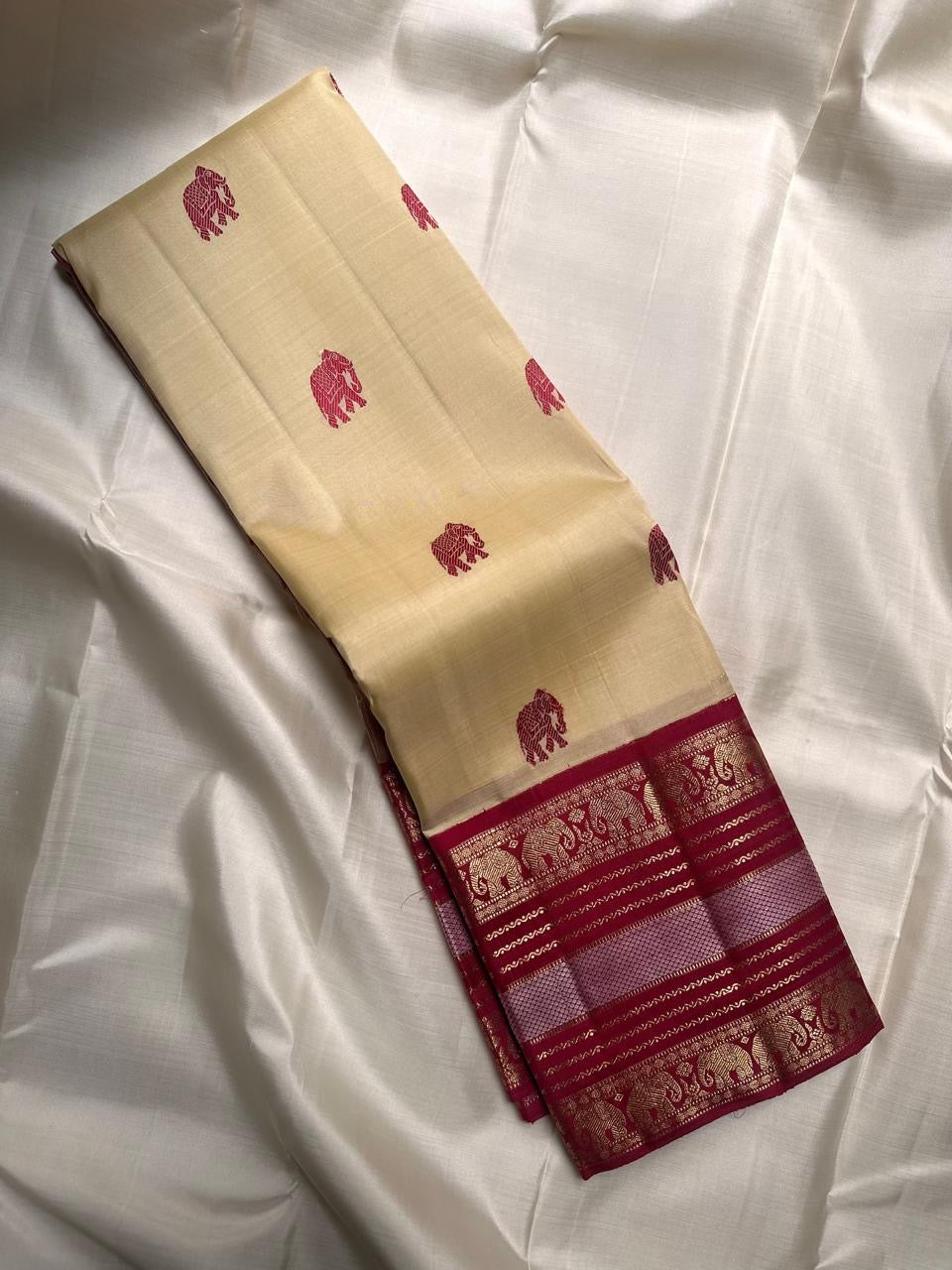 Cream Kanchipuram silk saree with Varisaipet elephant motif maroon border, front view