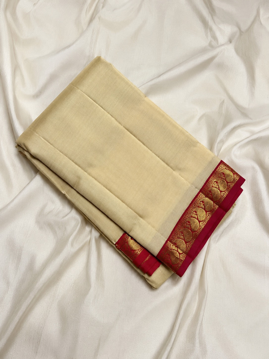 Cream Kanjivaram saree with red Paisley gold zari border