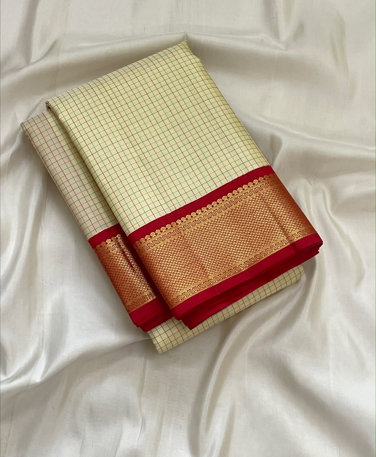 Cream and red Kanchi Kattam saree folded, full view